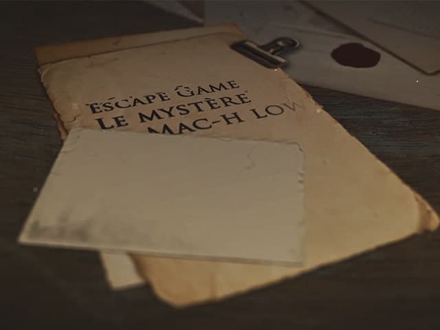Enveloppe kraft avec titre de l'escape game, décor énigmatique chez Émeraude Escape à Dinard