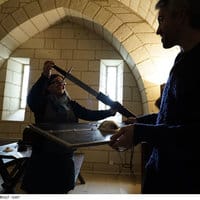 Deux joueurs interagissent dans une voûte en pierre, cadre médiéval de la Forteresse royale de Chinon
