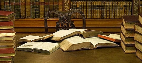 Grand bureau couvert de livres anciens ouverts, salle La bibliothèque chez Escape Hotel à Calais