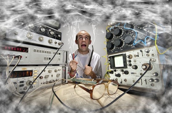 Homme entouré d'équipements électroniques et de câbles, ambiance technique et urgente