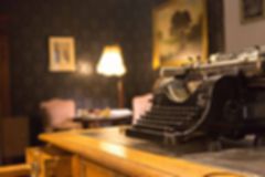 Machine à écrire ancienne sur un bureau en bois dans un salon éclairé par une lampe, salle Sherlock House à Perpignan