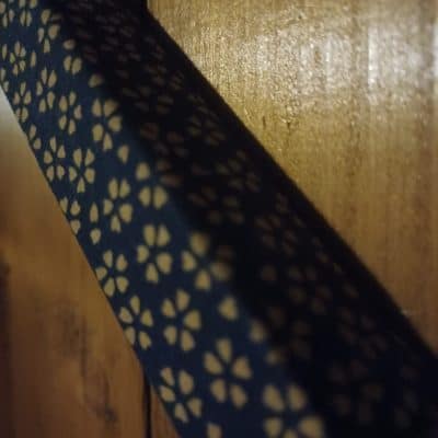 Longue bande de tissu bleu à motifs de fleurs claires sur du bois, salle Disparitions chez Zone 72 au Mans
