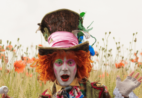Personnage maquillé aux cheveux orange vif dans un champ de fleurs chez Mind and Run Aix-en-Provence