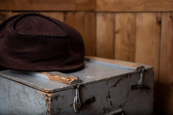 Valise usée et chapeau sur fond de bois dans Le Trésor perdu, Besançon