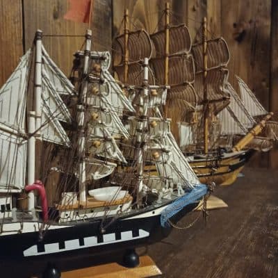 Maquettes de voiliers à voiles blanches sur une table de bois, salle L'héritage de tante Suzanne chez Zone 72