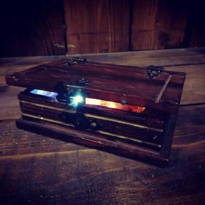 Boîte en bois à tiroir lumineux bleu et rouge sur du parquet, salle L'héritage de tante Suzanne, Zone 72 au Mans