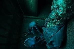 Créature verdâtre au visage décharné dans un recoin sombre, salle Paranormal chez Time Adventure à Reims
