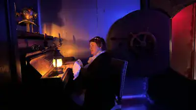 Capitaine en veste sombre près d'une lanterne et d'un volant de navire, éclairage bleu et rouge, salle Sous-marin Nautilus