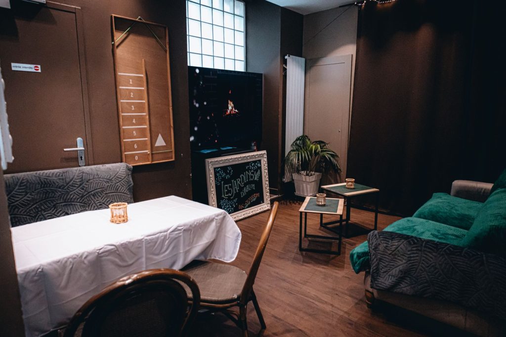 Un petit groupe d'amis éclairé par une lampe torche dans une pièce sombre d'escape game.