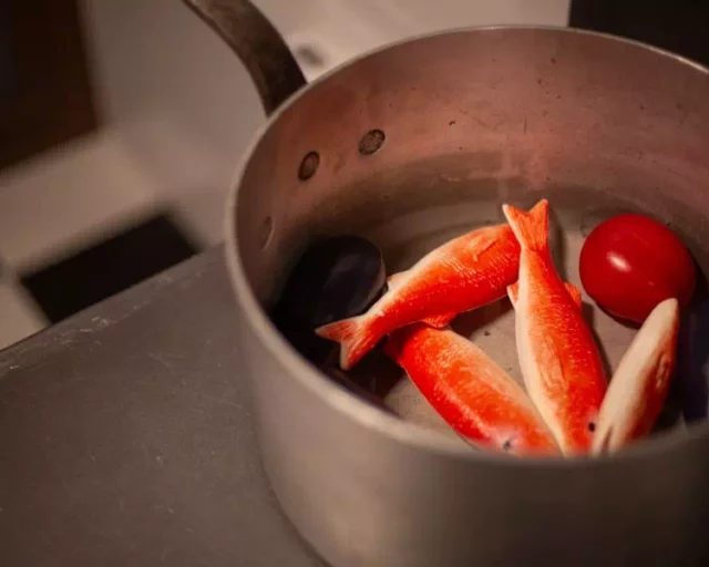 Casserole contenant des poissons rouges et blancs et une tomate, salle Panique en cuisine chez Gaillard Académie à Brive