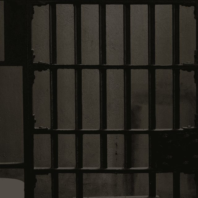 Barreaux de prison en béton gris, cellule sombre chez LA GRANDE ÉVASION