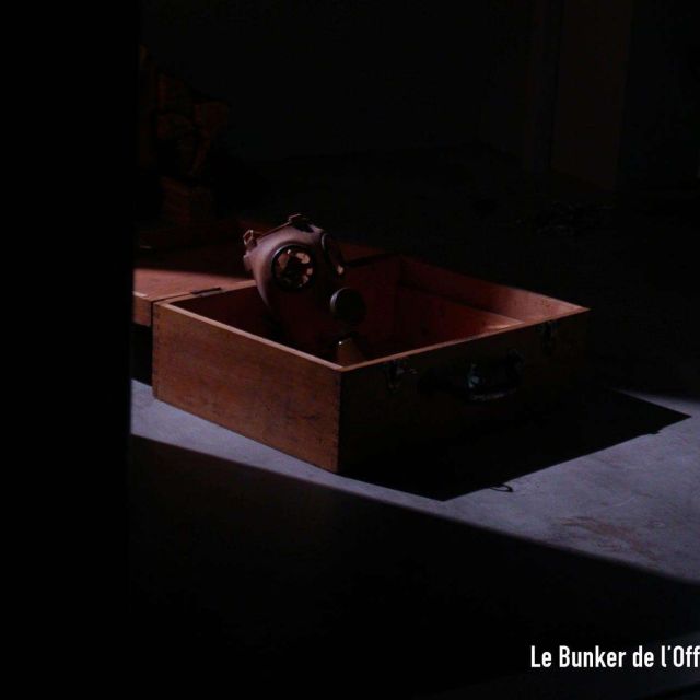 Coffre de bois posé dans l'obscurité et logo Game of Room en coin, salle Le Bunker de l'Officier Von Vokte à Villeurbanne
