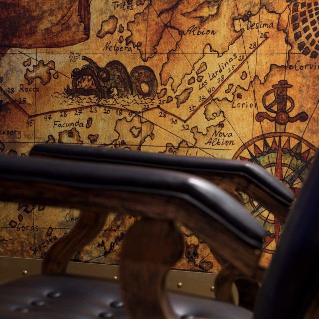 Carte marine ancienne aux monstres dessinés et rampe de métal, salle Nautilus chez Le Défi des Ducs à Dijon