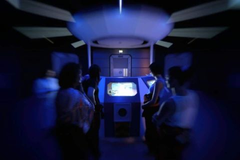 Intérieur futuriste bleu avec joueurs autour d'un terminal tactile chez Winscape à Argenteuil