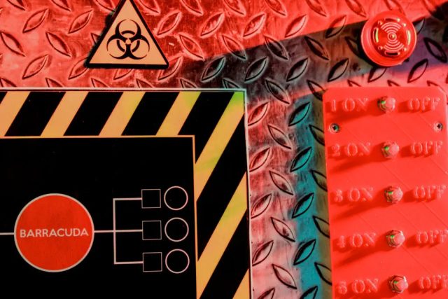 Tableau de bord rouge et noir avec signal de danger biologique et interrupteurs, salle SCEP Unité Spéciale, Grenoble