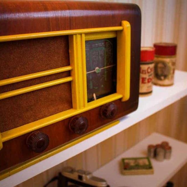Vieux poste radio en bois et métal jaune dans la salle La Voix de Londres