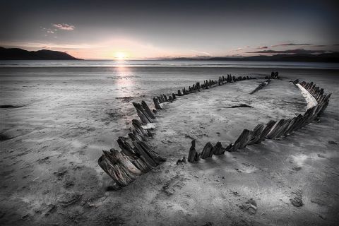 Squelette de coque de navire échoué sur une plage au coucher du soleil, salle Le pirate sanguinaire chez Cryptom06 à Castellar