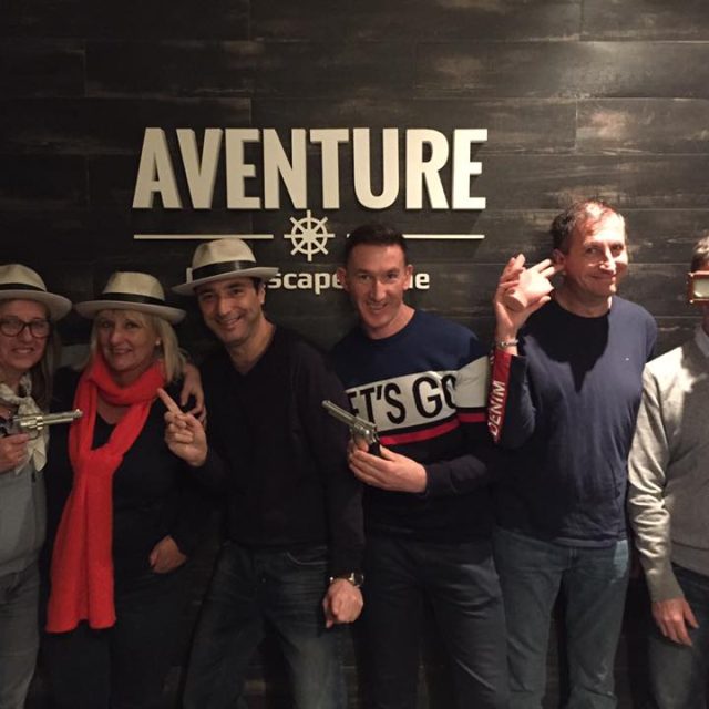 Groupe de six personnes posant devant le logo Aventure Live! Escape Game à Nice