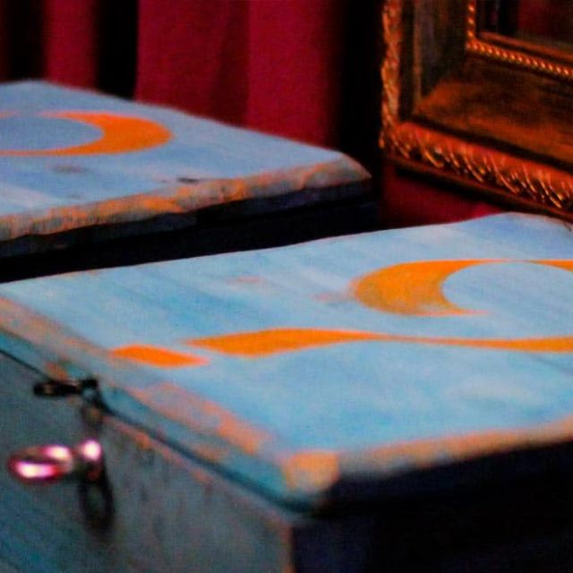 Malles bleues avec motifs orange et cadre doré, décor vintage d'Escape Circus chez Escape Time à Barjouville