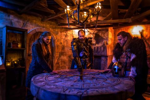 Quatre joueurs autour d'une table ronde magique, décor médiéval-fantasy à la Malédiction de Morgane chez Escape Dimension à Saleilles