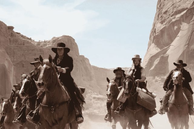 Cavaliers en costume western chevauchent dans un canyon aride chez Heyou à Cannes