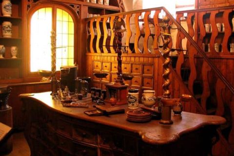Atelier de luthier avec instruments suspendus, établi et outils dans une ambiance chaleureuse chez Chamber Challenge