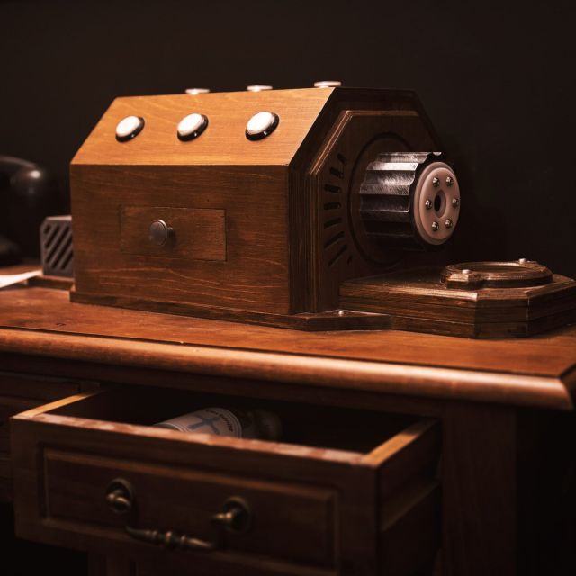 Secrétaire de bois avec téléphone ancien et boîtier à boutons, tiroir ouvert, salle Dracula chez Hint Hunt à Paris