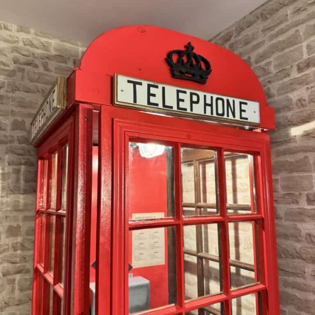 Cabine téléphonique rouge britannique portant le mot Telephone, décor des salles d'Escape Factory à Guérande