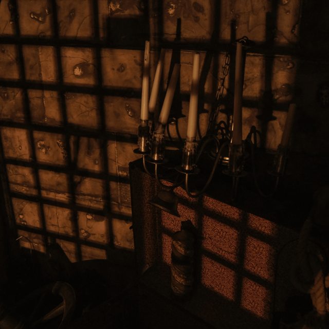 Grille de fer et ombres dans une pièce très sombre, salle Les souterrains de Richelieu chez La Boîte à CL-é