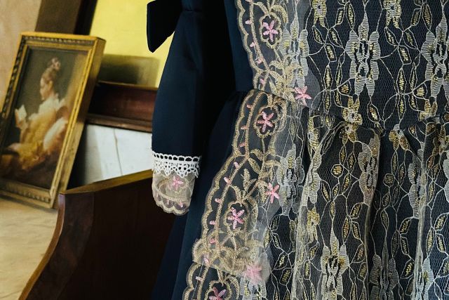 Dentelle noire et cadres dorés posés sur un meuble, salle Murder Mystery Enquête géante au Château du Vot à Trédarzec