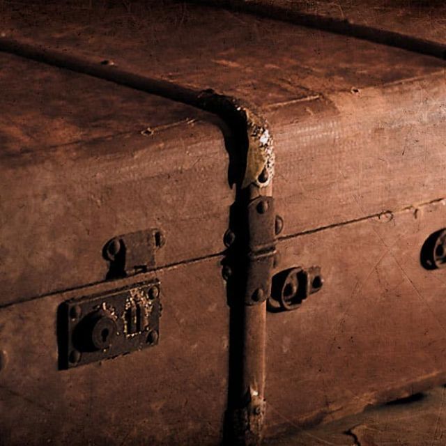 Vieilles malles en cuir empilées, éclairage dramatique, ambiance vintage dans Le Silver Express