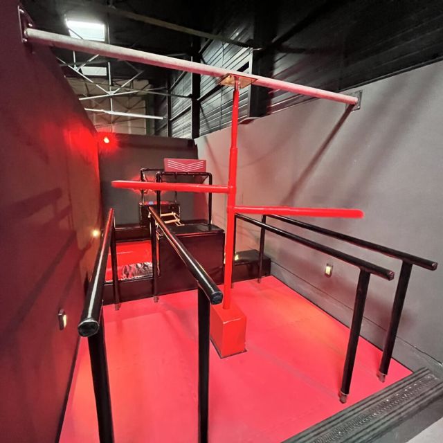 Parcours de barres métalliques au sol rouge sous un éclairage rouge, Cube Challenges chez Team Square à Hénin-Beaumont