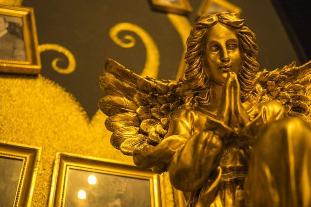 Statue dorée d'ange ailé dans la salle Le mystère de la dame rouge chez ToulousEscape