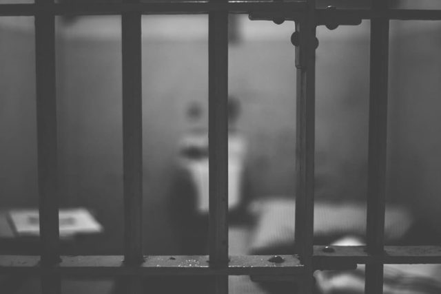 Barreaux de cellule gris et flous devant une table, noir et blanc, salle Opération évasion, TimeXperience à Pélissanne
