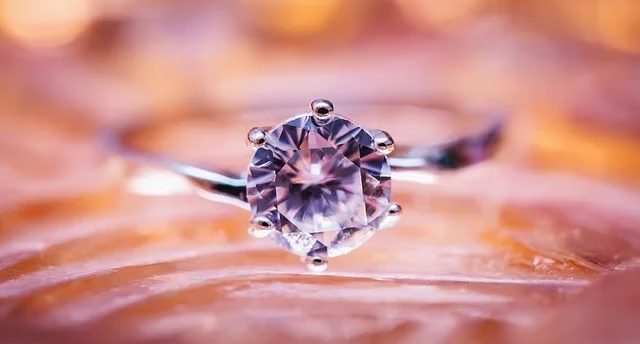 Bague en or sertie d'un gros diamant posée sur un tissu cuivré, salle Le diamant chez Escape One à Pontault-Combault