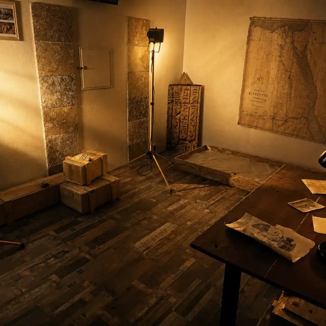 Décor égyptien avec cartographies murales, hiéroglyphes et objets archéologiques dans La malédiction du pharaon