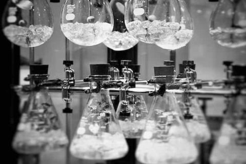 Ballons de laboratoire en verre en noir et blanc, mot Labo en rouge, salle Laboratoire Futur chez Games Escape Game à Mornant