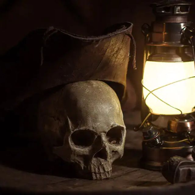 Crâne sous un chapeau de pirate près d'une lanterne allumée, Le Repaire de Rackham