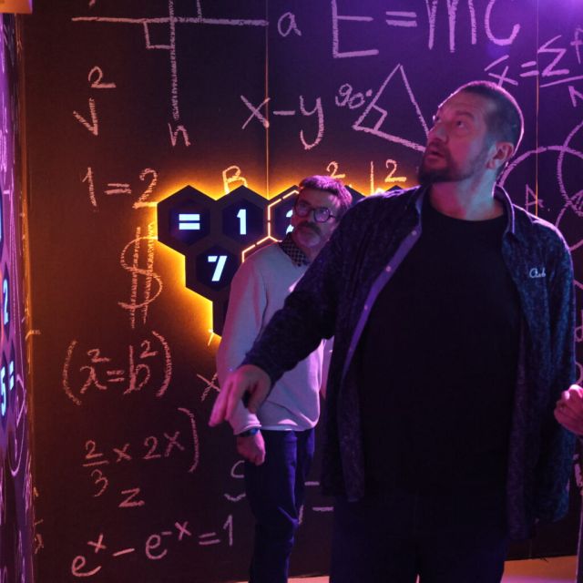 Joueurs devant un tableau noir de formules colorées et un panneau à hexagones, Cube Challenges chez Team Square à Hénin-Beaumont