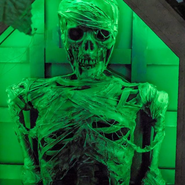 Momie enveloppée de bandelettes illuminée en vert fluo dans Le tombeau perdu