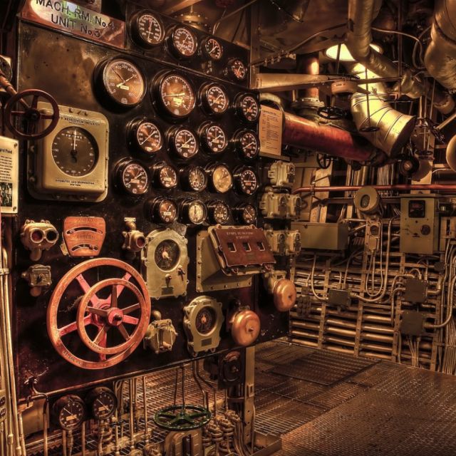 Salle des machines de sous-marin avec cadrans, tuyaux et volant rouge, salle Sur les traces du magicien, Magicbus à Potelle