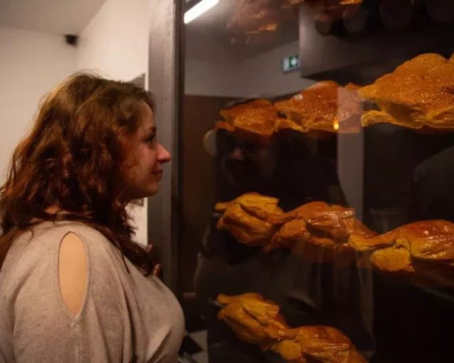 Joueuse devant une rôtissoire garnie de poulets dorés, salle Panique en cuisine chez Gaillard Académie à Brive-la-Gaillarde