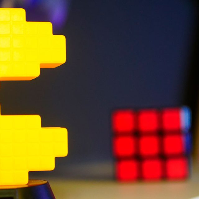 Pac-Man jaune lumineux posé près d'un cube rouge, décor rétro de la salle Super Alpha World chez Escape Time à Angers
