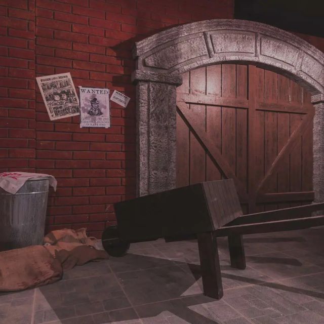 Cellule de prison en briques rouges avec porte en bois, banc et avis de recherche, Jack The Ripper Geneva