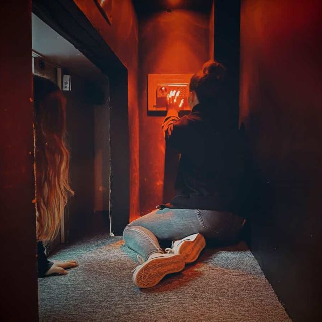 Joueurs explorant un couloir rouge sombre aux parois métalliques chez Freeing! à Saint-Maximin