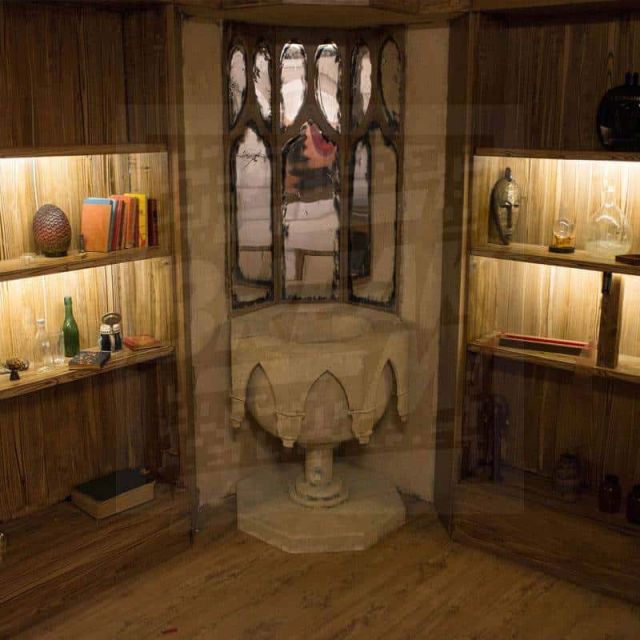 Cabinet aux murs boisés, vitrines éclairées et statue centrale dans Magic School