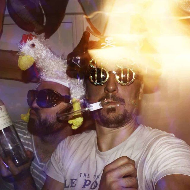 Deux joueurs en costumes de fête avec accessoires dorés dans Very Bad Night, enseigne One Hour à Paris