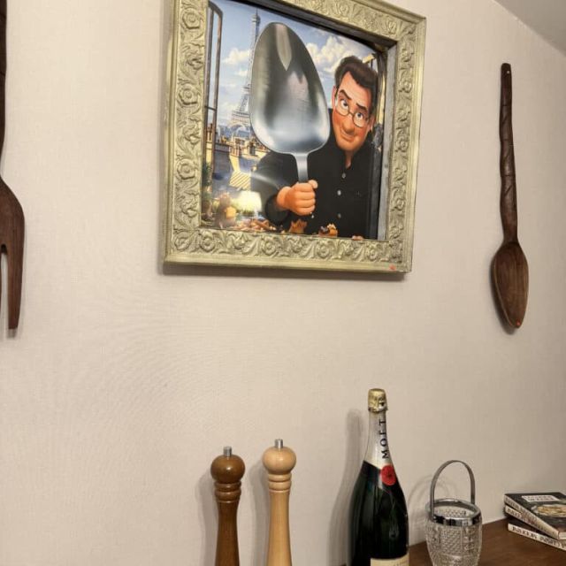 Portrait encadré d'un homme tenant un plat, moulin à poivre et champagne, salle Le grand restaurant chez Escape Factory à Guérande