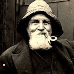 Homme âgé à barbe blanche et pipe, coiffé d'une casquette, portrait noir et blanc vintage chez Mystère de Mac'h low