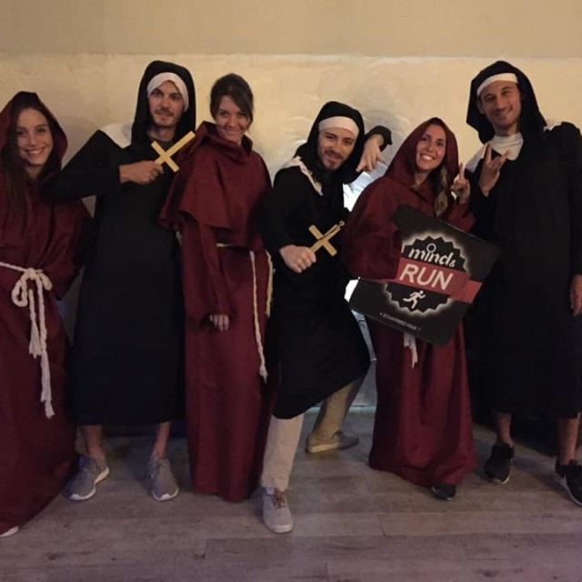 Six personnes en robes et coiffes religieuses posent devant un mur beige chez Mind and Run Aix-en-Provence